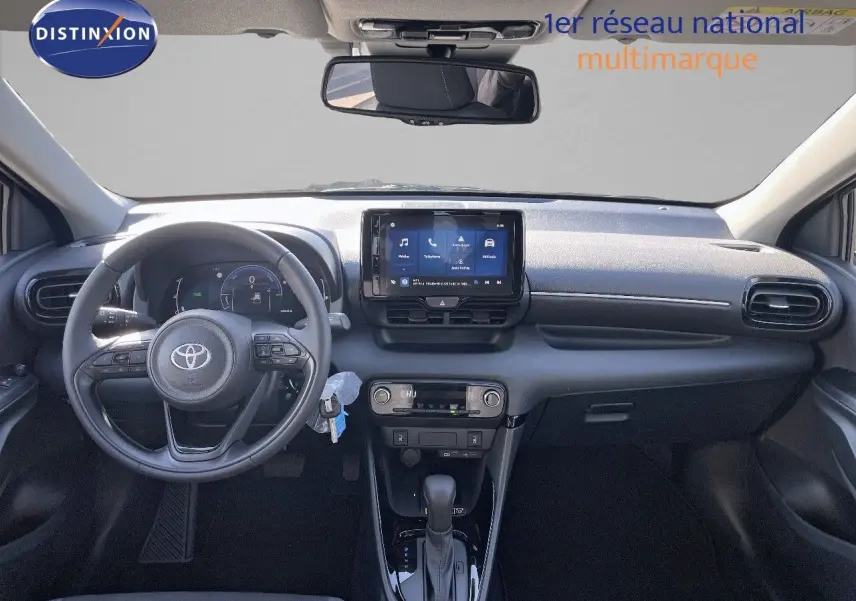 Intérieur de la Toyota Yaris Hybrid 2025 en noir, vue frontale du tableau de bord avec écran tactile et volant multifonction.