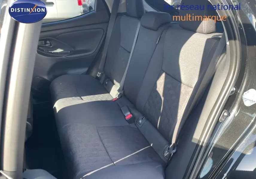 Vue intérieure arrière côté droit de la Toyota Yaris Hybrid 116ch 2025 avec sièges tissu noir et porte ouverte noir métal.