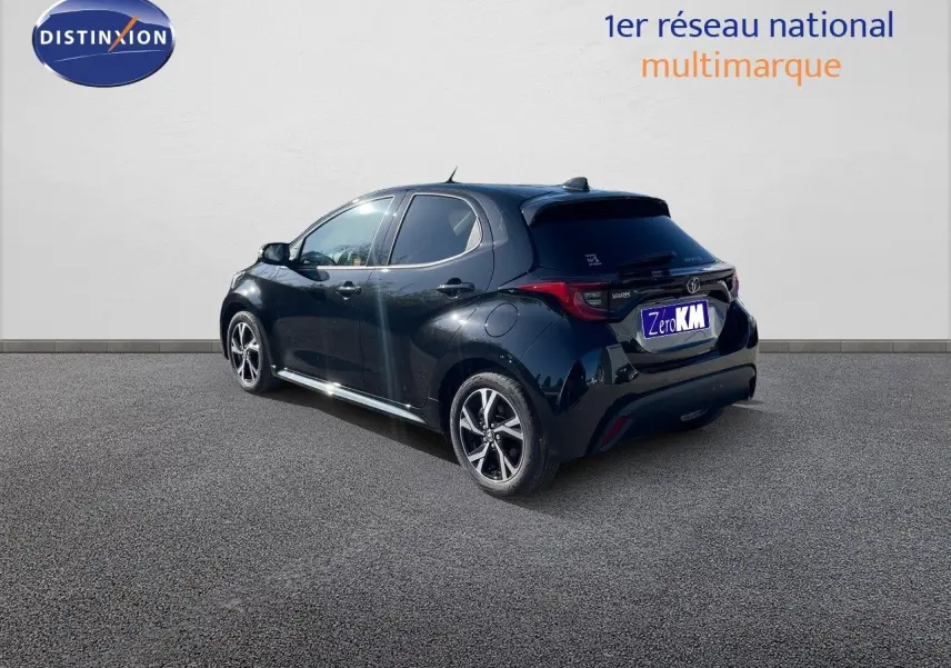 Toyota Yaris Hybrid 116ch noir métal vue 3/4 arrière côté gauche avec jantes bi-ton et feux LED distinctifs.