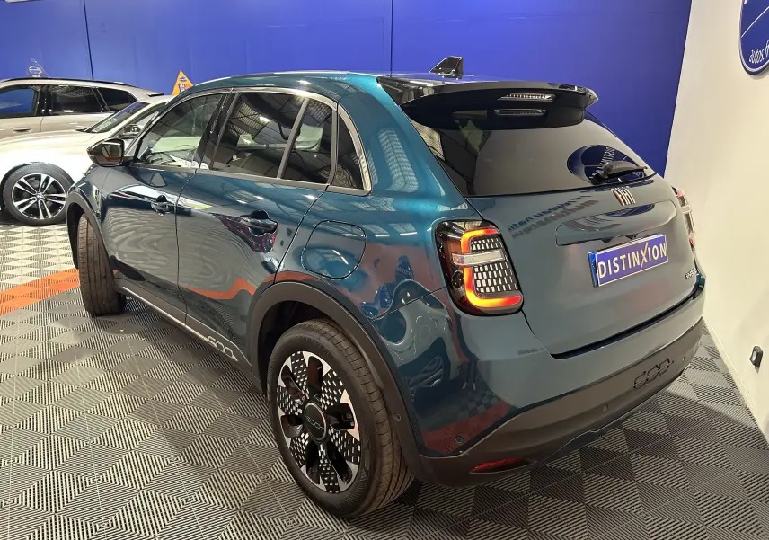 Vue 3/4 arrière droite d'une FIAT 600 Hybrid 100 La Prima bleu avec hayon électrique et feux arrière LED distinctifs.