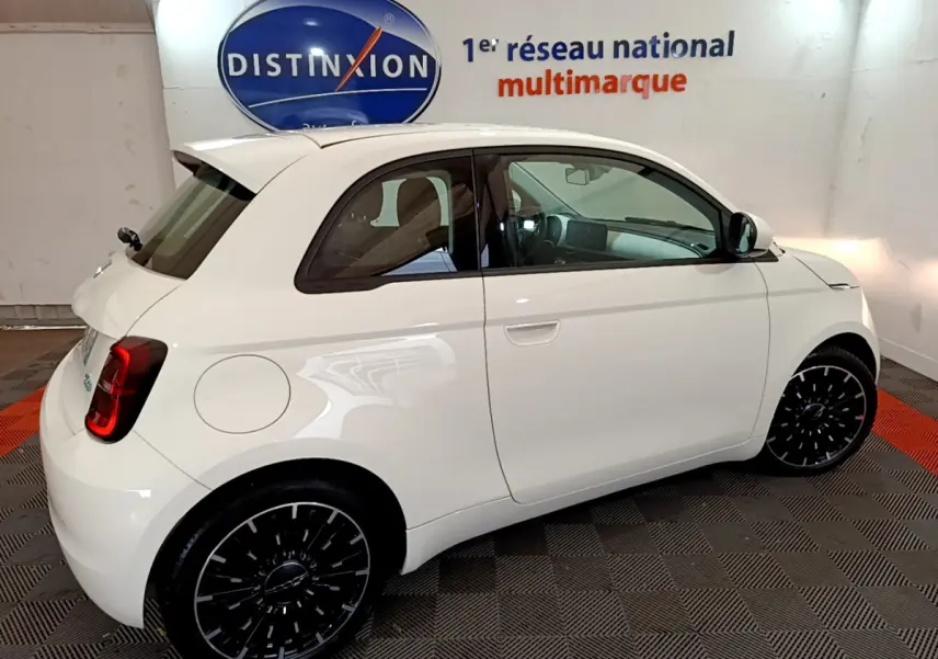 Profil droit de la Fiat 500 électrique blanche 42kWh Icône 2022, avec jantes noires et intérieur visible.