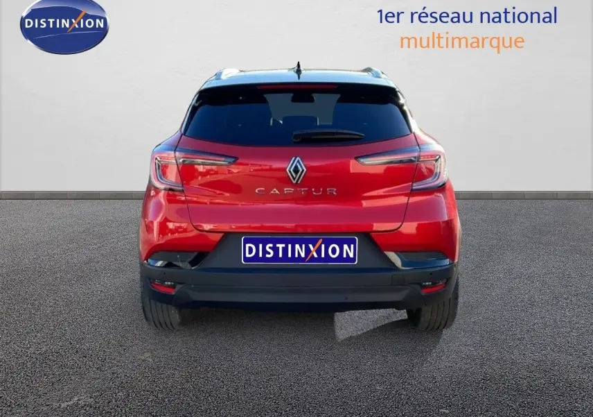 Vue arrière d'un Renault Captur rouge désir métal avec toit noir, mettant en valeur ses feux LED et son logo central.