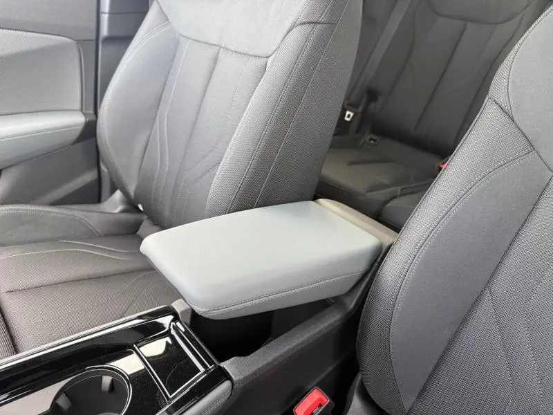 Gros plan sur l'accoudoir central gris et les sièges avant en tissu gris foncé de l'Audi Q3 2026.