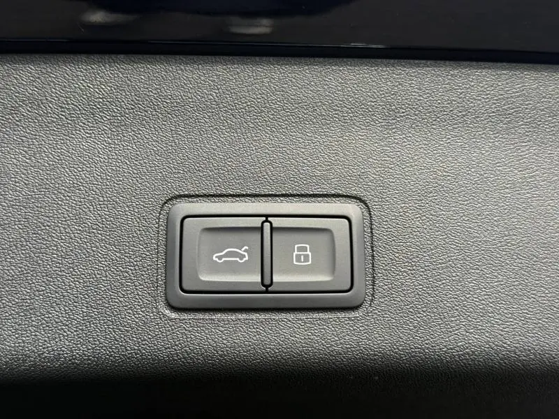 Boutons de commande pour ouverture du coffre et verrouillage, intégrés dans un panneau intérieur noir texturé d'Audi Q3 2.0 TDI 2026.