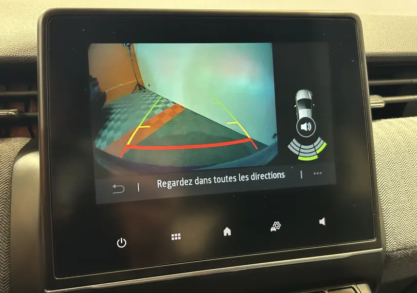Écran central montrant la caméra de recul avec guidage coloré et alertes de proximité sur Renault Clio V.