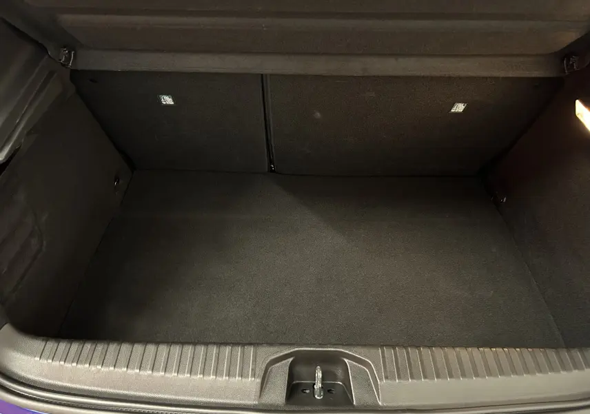 Coffre vide vu de face d'une Renault Clio V bleu Iron Metal, montrant un espace de rangement propre et bien fini.