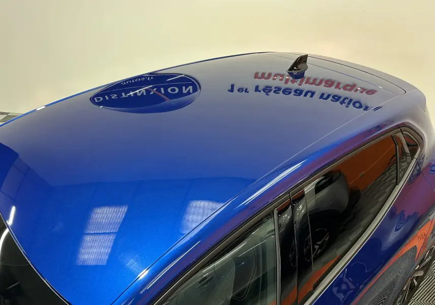 Vue plongeante sur le toit bleu iron metal et la partie supérieure côté droit de la Renault Clio V hybride 2025.
