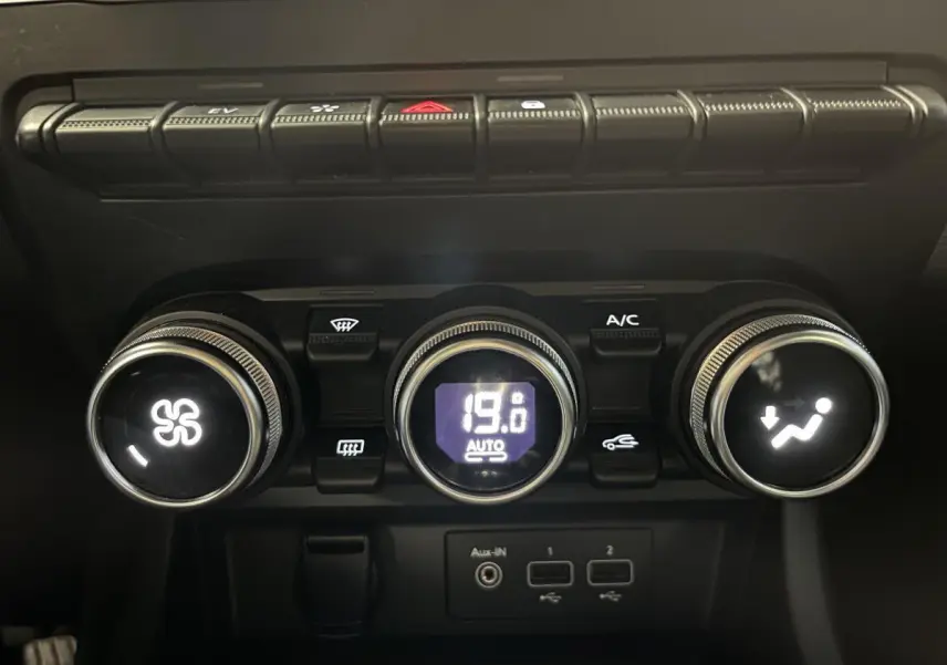 Commandes de climatisation automatique avec affichage digital et ports USB dans l'habitacle noir du Renault Arkana 2021.