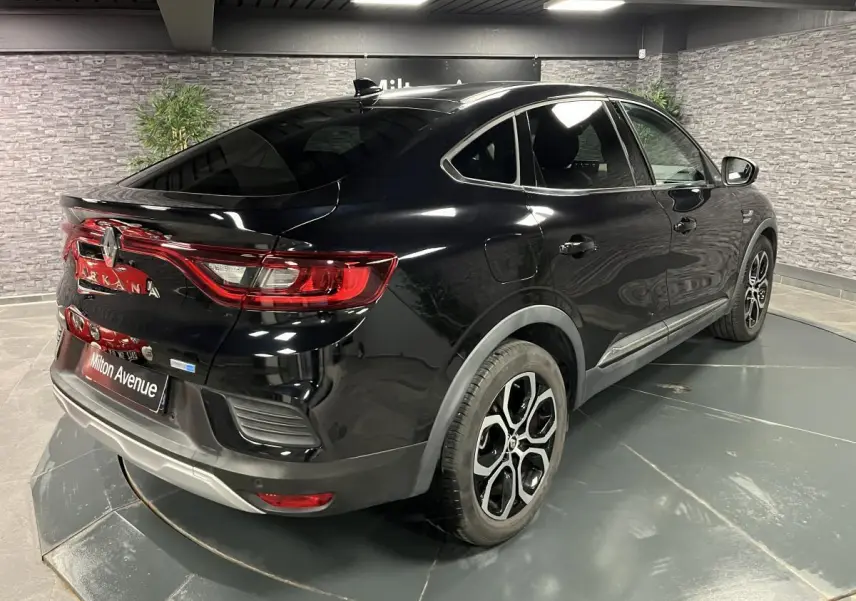 Renault Arkana noir métal vu en 3/4 arrière droit, avec jantes alliage noires et feux arrière LED distinctifs.