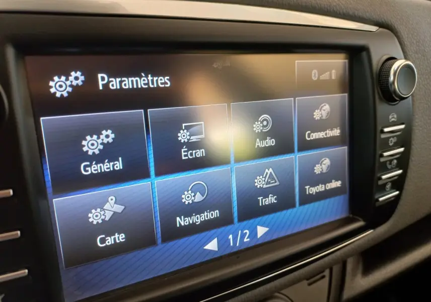 Écran tactile central de la Toyota Yaris hybride 2019 affichant le menu paramètres en intérieur noir.
