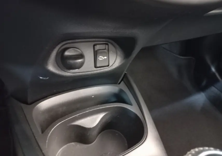 Gros plan sur la console centrale noire de la Toyota Yaris 2019, avec prise USB et allume-cigare visible.