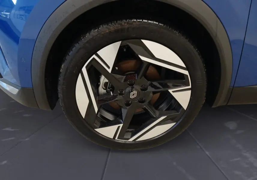 Gros plan sur la roue avant droite du Renault Symbioz 2025 bleu iron, mettant en valeur la jante noire et blanche au design géométrique.