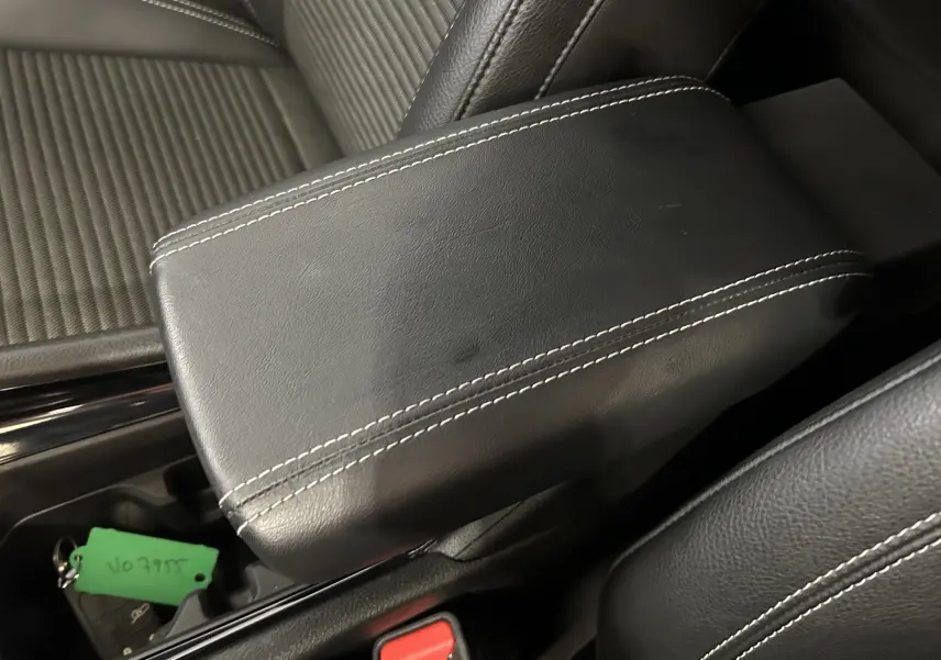 Gros plan sur l'accoudoir central en cuir noir avec surpiqûres blanches dans l'habitacle du Jeep Compass gris.