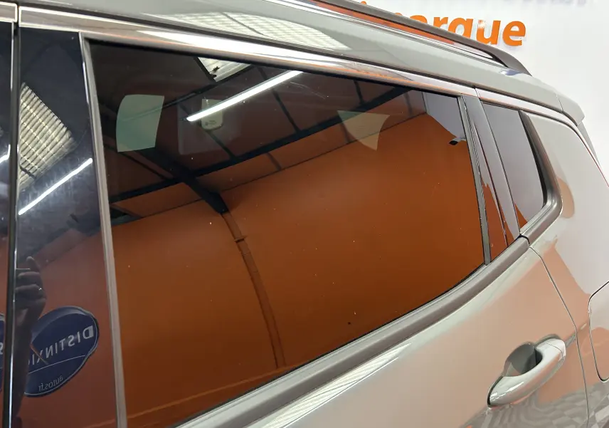 Vue latérale droite sur la porte arrière d'un Jeep Compass gris avec vitres teintées et poignée intégrée.