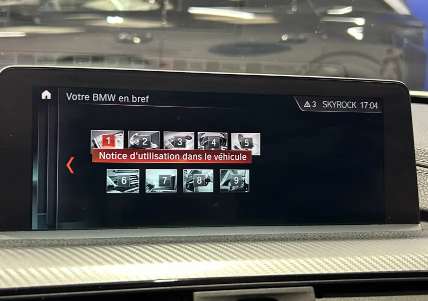 Écran central de la BMW Série 3 320i 2018 affichant la notice d'utilisation du véhicule en intérieur.