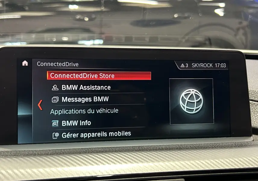 Écran central du système BMW ConnectedDrive affichant le menu principal dans l’habitacle d’une BMW Série 3 blanche.