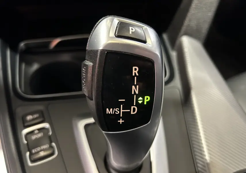 Le levier de vitesses automatique de la BMW Série 3 320i 2018 en gros plan avec indication mode parking verte.