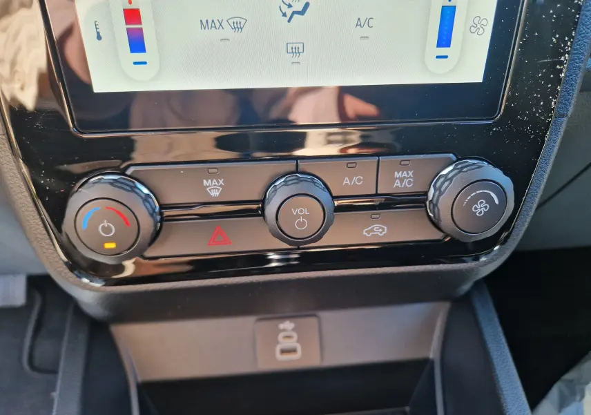 Gros plan sur la console centrale du Ford Ranger Super Cabine 2026 gris carbone, montrant les commandes de climatisation et volume.