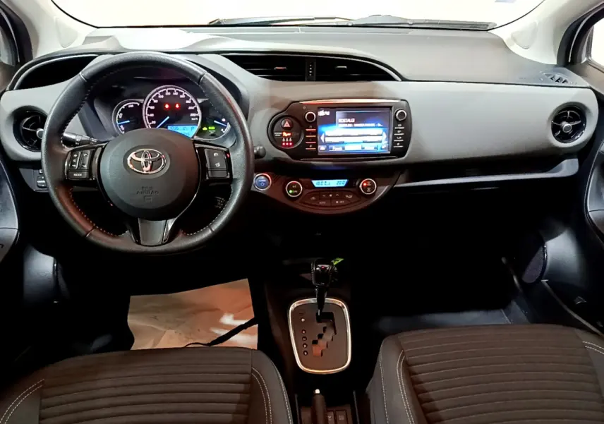 Tableau de bord et console centrale de la Toyota Yaris blanche 2020, vue frontale intérieure avec écran tactile et volant cuir.