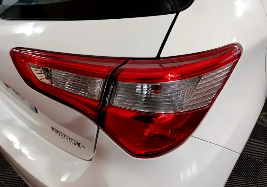 Gros plan sur le feu arrière droit rouge et blanc d'une Toyota Yaris 1.5 Hybride blanche de 2020.