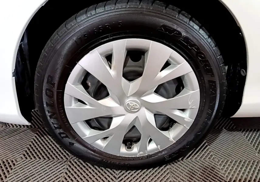 Gros plan sur la roue avant droite blanche d'une Toyota Yaris 1.5 Hybride 2020 avec jante en alliage argenté.