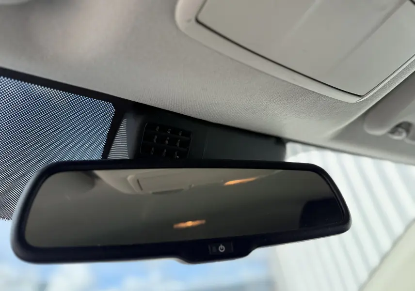 Rétroviseur intérieur de la Mazda3 gris 2017, vue rapprochée du miroir avec bouton d'anti-éblouissement intégré.