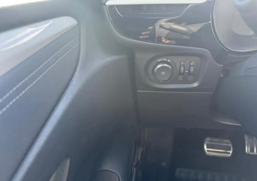 Détail du tableau de bord côté gauche de l’Opel Corsa 2025 avec commandes d’éclairage et pédales en aluminium.