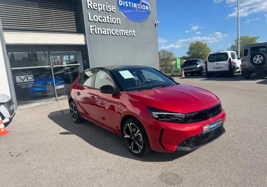 Vue 3/4 avant droite d'une Opel Corsa rouge 2025 avec jantes alliage 17 pouces, calandre noire et toit noir.