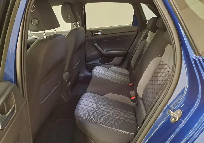 Vue intérieure arrière côté gauche de la Volkswagen Polo Bleu Récif, montrant les sièges arrière en tissu à motifs géométriques.