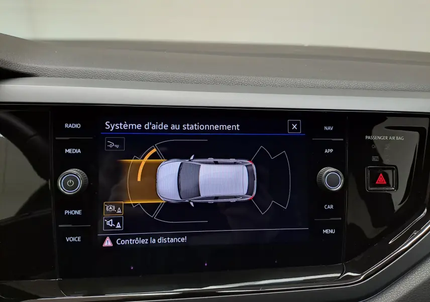 Écran tactile intérieur montrant le système d'aide au stationnement de la Volkswagen Polo 2025 en vue de dessus du véhicule.