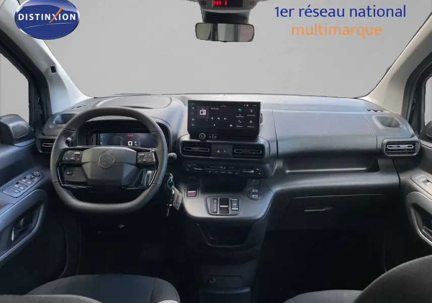 Vue intérieure avant du Citroën Berlingo noir Perla Nera, tableau de bord moderne avec écran tactile central et volant multifonction.