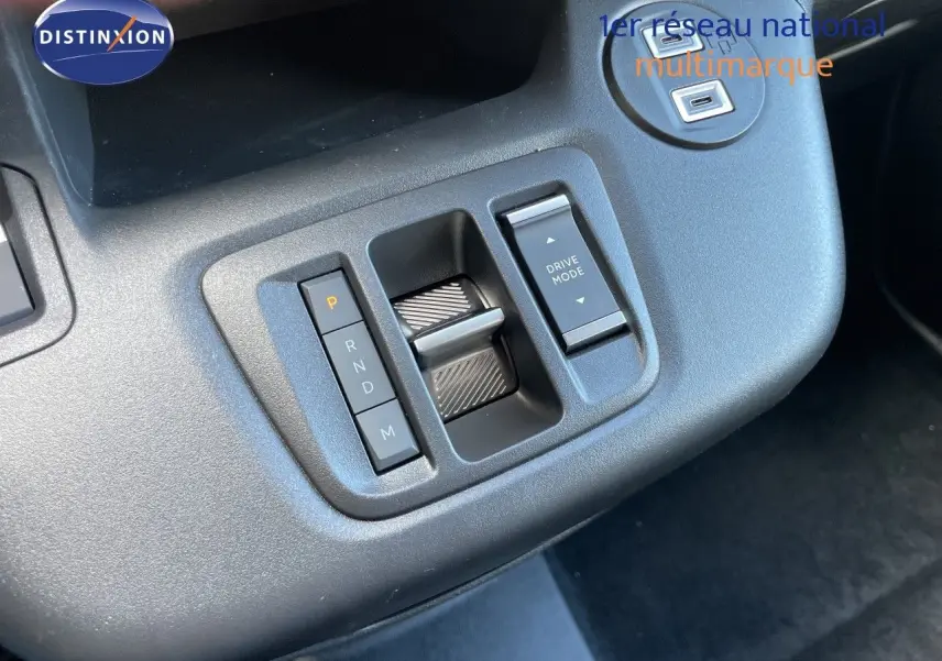 Gros plan sur la console centrale du Citroën Berlingo noir, montrant la commande de boîte automatique et le bouton Drive Mode.