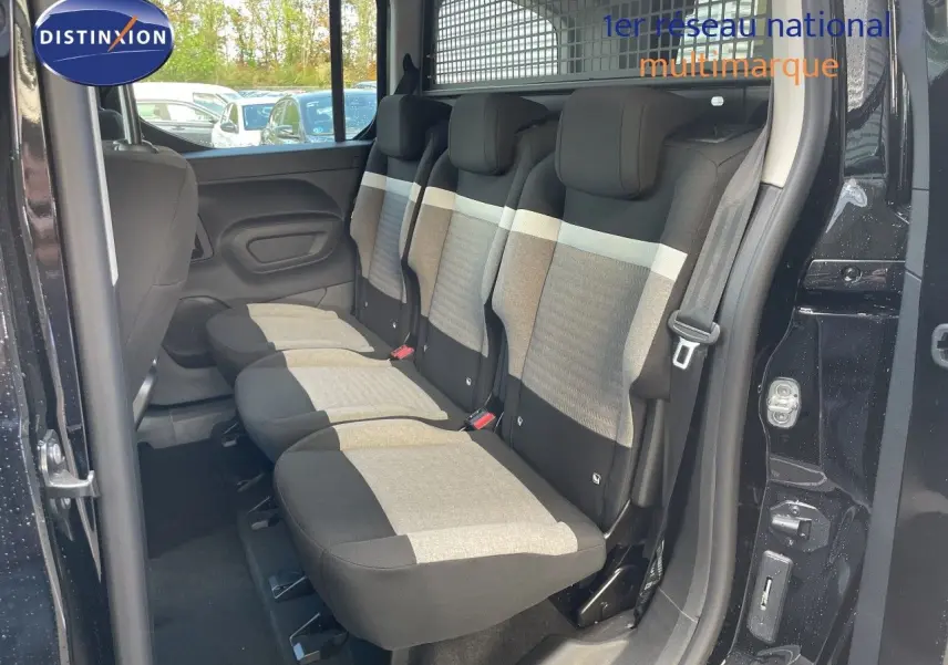 Vue latérale droite sur l'intérieur arrière du Citroën Berlingo noir, montrant les trois sièges tissu gris et noir.