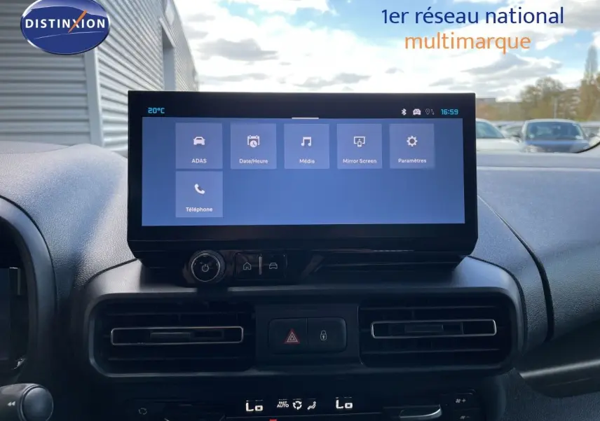 Vue intérieure centrée sur l'écran tactile du tableau de bord du Citroën Berlingo noir Perla Nera, avec commandes climatisation visibles.