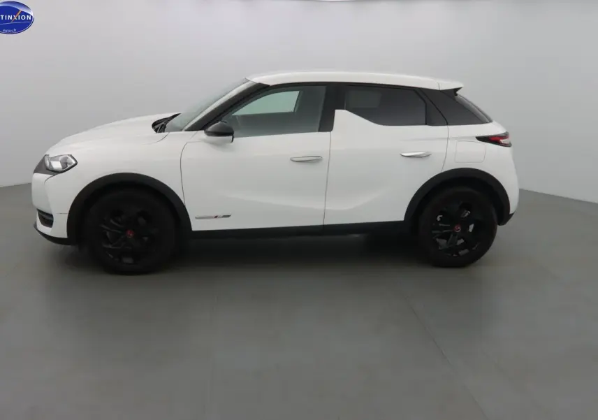Vue de profil côté gauche d'un DS3 Crossback blanc banquise avec jantes noires et toit contrasté noir.