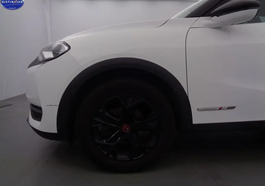 Vue de profil côté gauche sur l'avant blanc banquise du DS3 Crossback avec jante noire et badge Performance Line.