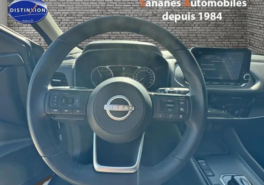 Vue rapprochée du volant multifonction noir du Nissan Qashqai 1.5 e-Power 2023 avec tableau de bord et écran tactile visible.