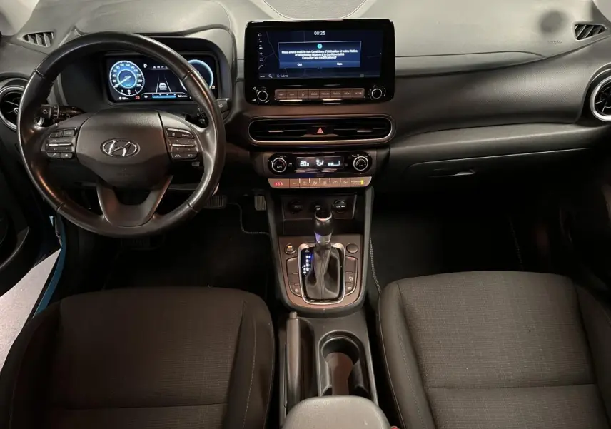 Vue intérieure avant du Hyundai Kona 1.6 CRDi Hybrid 48V avec tableau de bord numérique et écran tactile central.