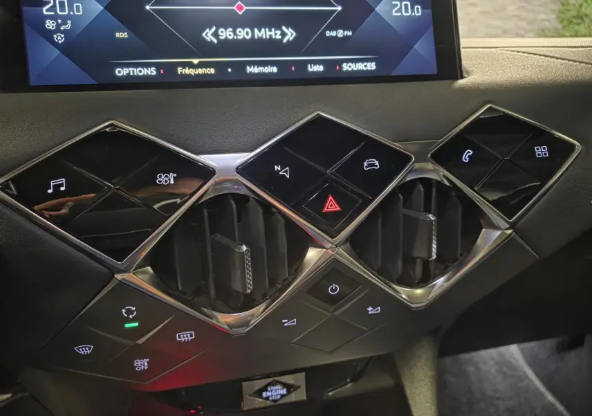 Détail du tableau de bord du DS3 Crossback 2022 montrant les commandes tactiles noires et les aérateurs centraux chromés.