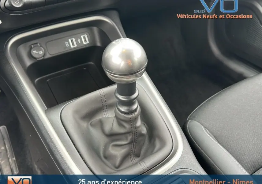 Gros plan sur le levier de vitesses manuel du Jeep Avenger gris foncé 2024, avec ports USB et prise 12V visibles.