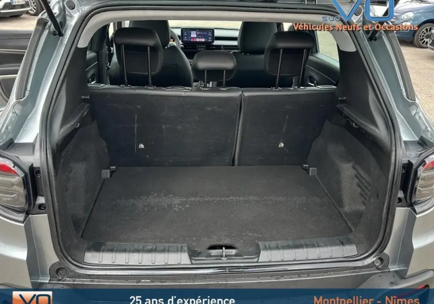 Coffre ouvert d'un Jeep Avenger gris foncé 2024, vue arrière montrant l'espace de chargement et les sièges arrière.