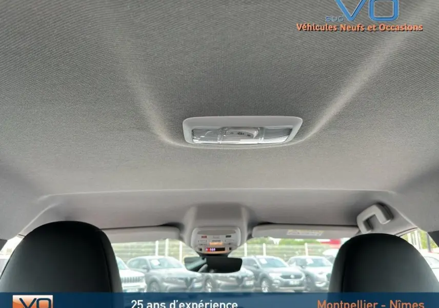 Vue intérieure du toit et plafonnier du Jeep Avenger gris foncé 2024, avec sièges avant visibles en partie.