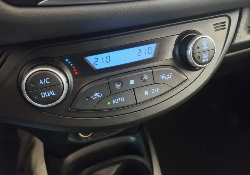 Vue rapprochée de la commande de climatisation bi-zone avec affichage digital dans une Toyota Yaris noire 2018.