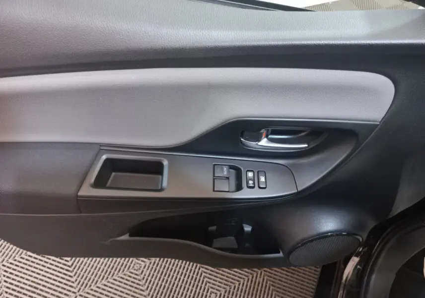 Vue rapprochée de la porte avant gauche noire de la Toyota Yaris 2018 avec commandes de vitres et poignée chrome.