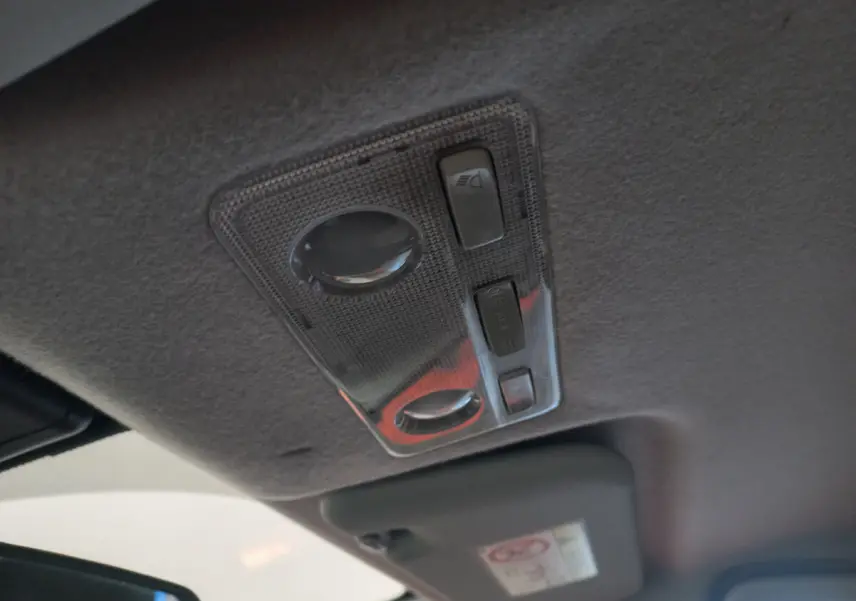 Plafonnier intérieur avec commandes d'éclairage sur le toit d'une Toyota Yaris noire hybride de 2018.