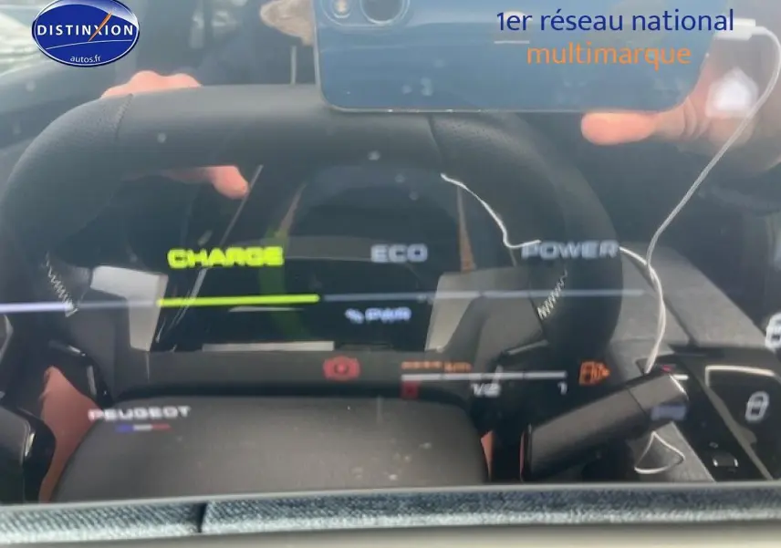 Vue rapprochée du tableau de bord numérique et volant cuir du Peugeot 3008 gris titane hybride 2025.