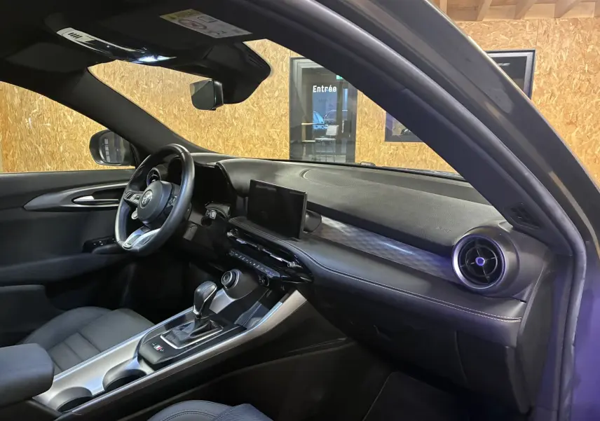 Intérieur noir de l'Alfa Romeo Tonale 1.3 PHEV 280 BVA TI, vue côté conducteur avec tableau de bord et écran central.