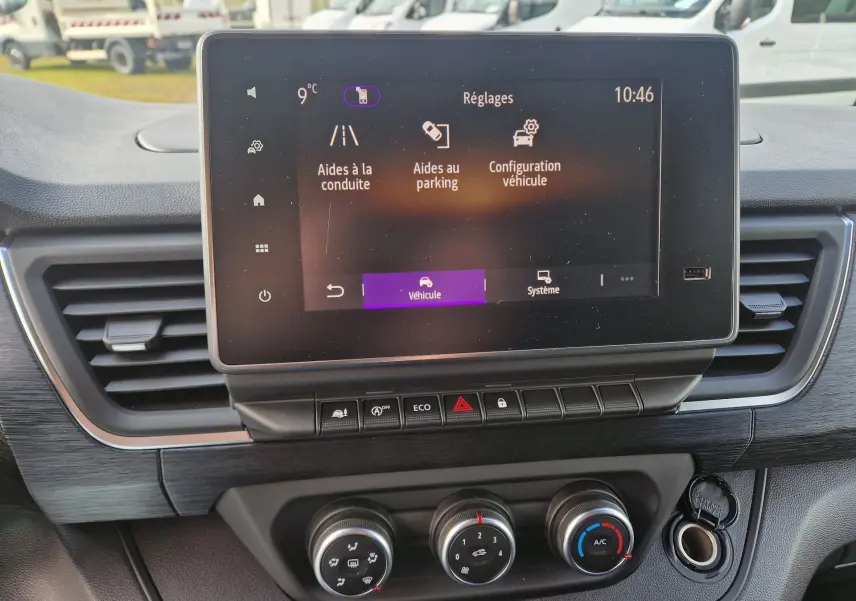 Vue rapprochée de l’écran tactile central et des commandes de climatisation du Nissan Primastar blanc, version 2025.