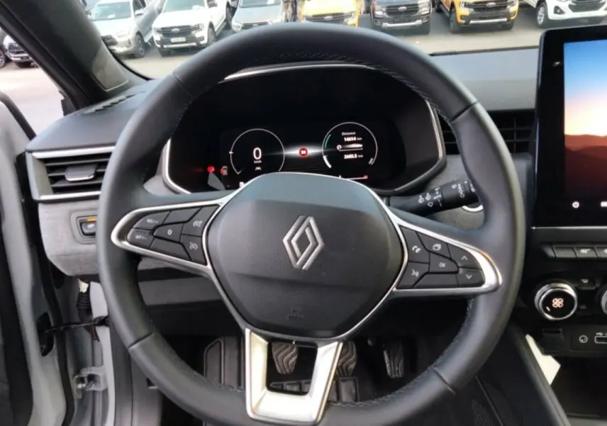 Vue rapprochée du volant cuir multifonctions et du tableau de bord numérique de la Renault Clio gris rafale 2025.