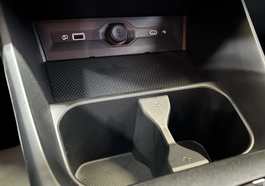 Gros plan intérieur sur la console centrale noire du MG3 1.5 Hybrid+ 195 Luxury avec prises USB et allume-cigare.
